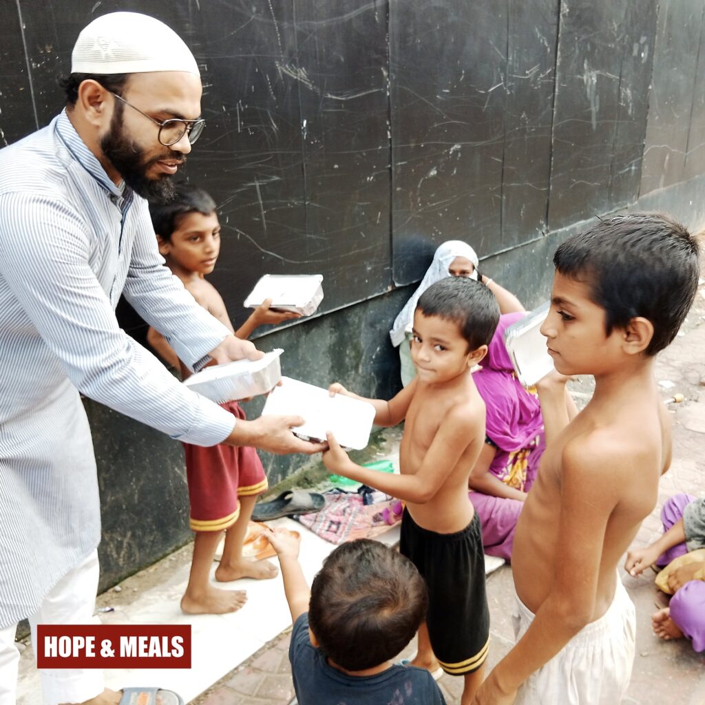 Group of children happily holding their free meal boxes provided by Hope & Meals.